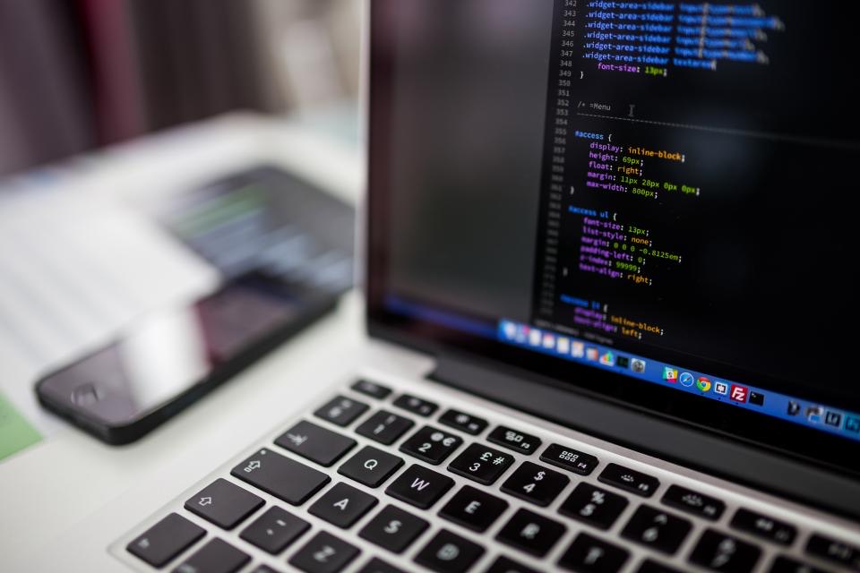 Code on a laptop screen in a dim office